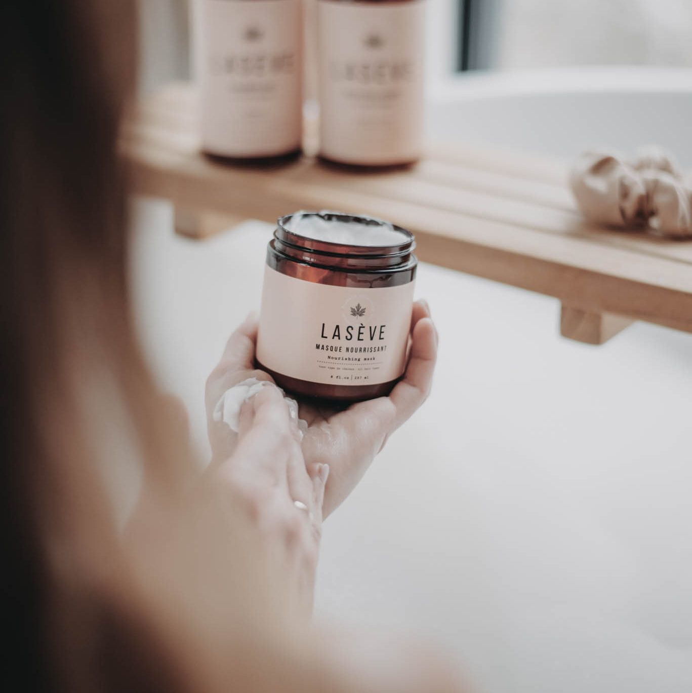 Une femme tiens dans les mains un produit de la marque Lasève : Le masque nourissant Lasève