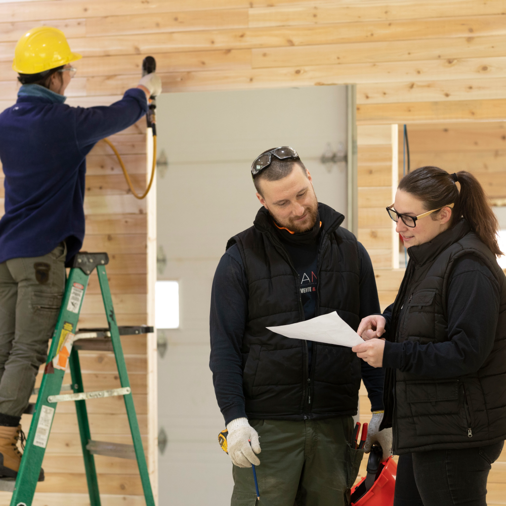 Camille Therrien-Tremblay, au travail, discutant de son entreprise CAMM construction avec un employé.